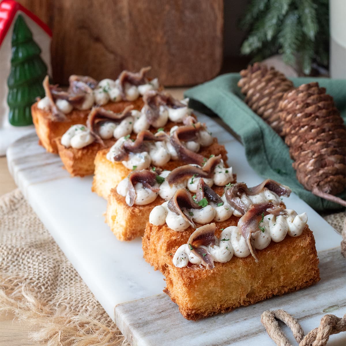 Canapé de pan brioche con mantequilla trufada y anchoas en Olla GM